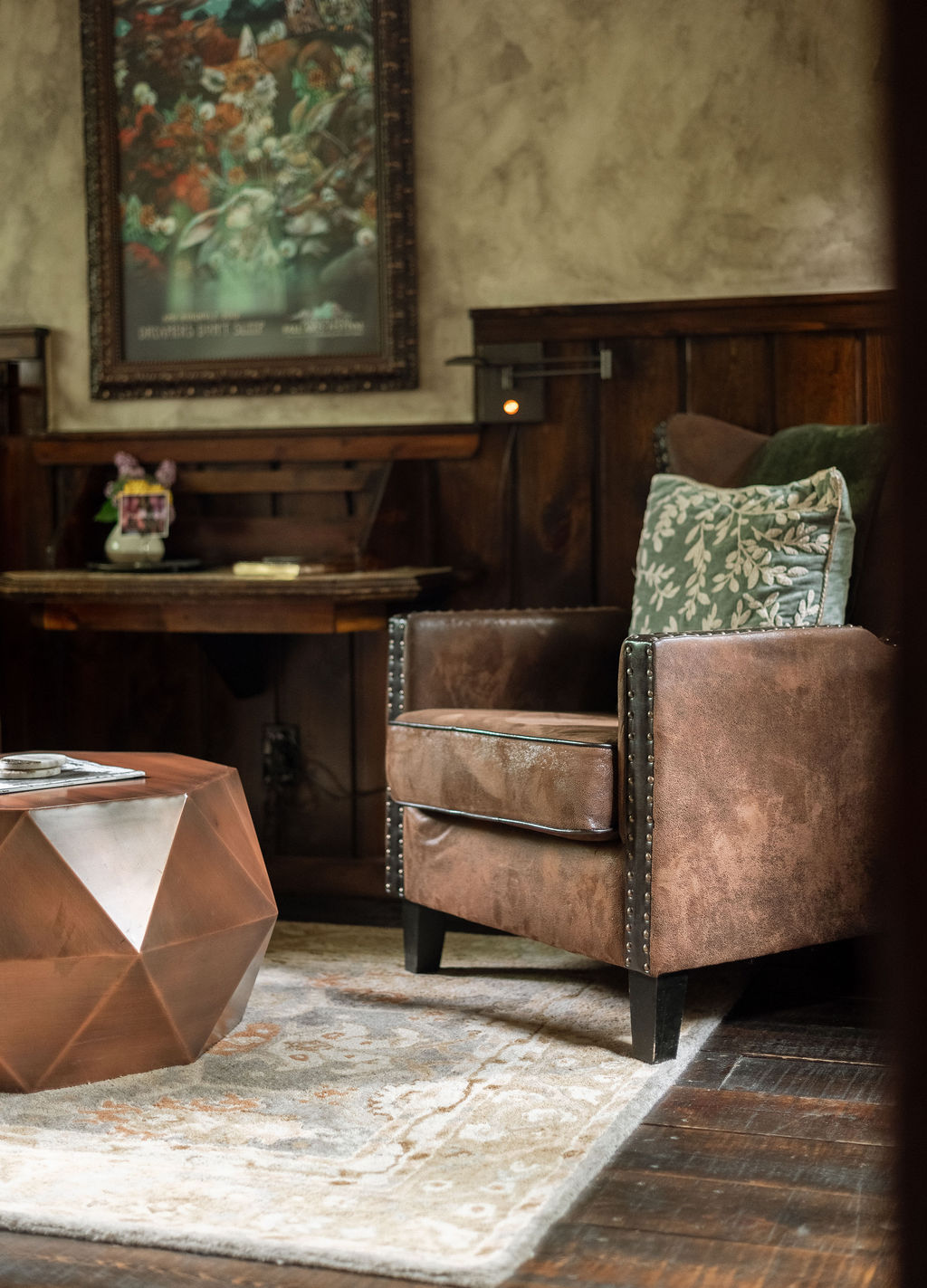 Sitting area with two brown deluxe chairs, an Atonement to rest your feet, and a gas fireplace. with log beams above.