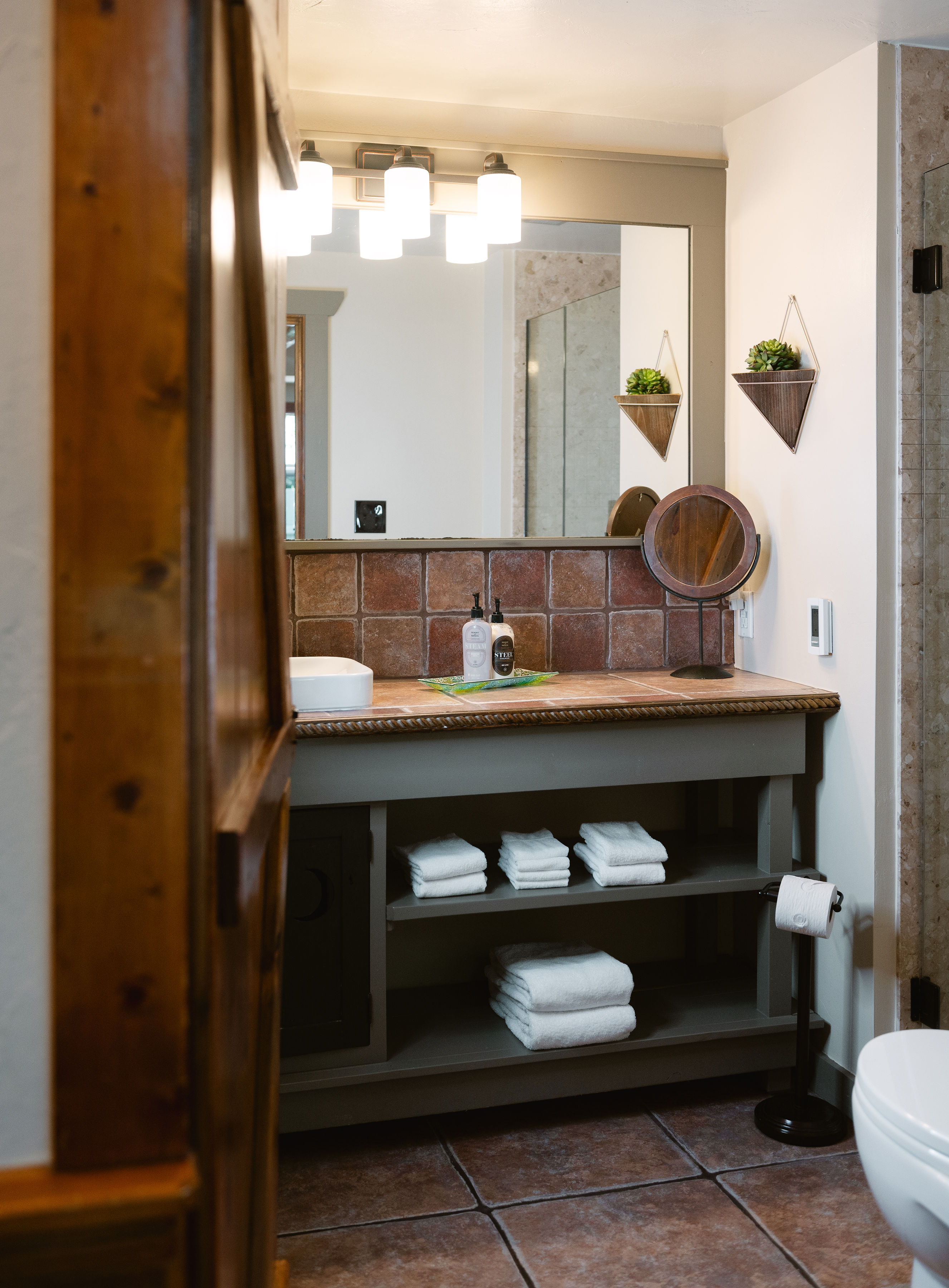 glass door to spacious bathroom, tile floor and large mirror