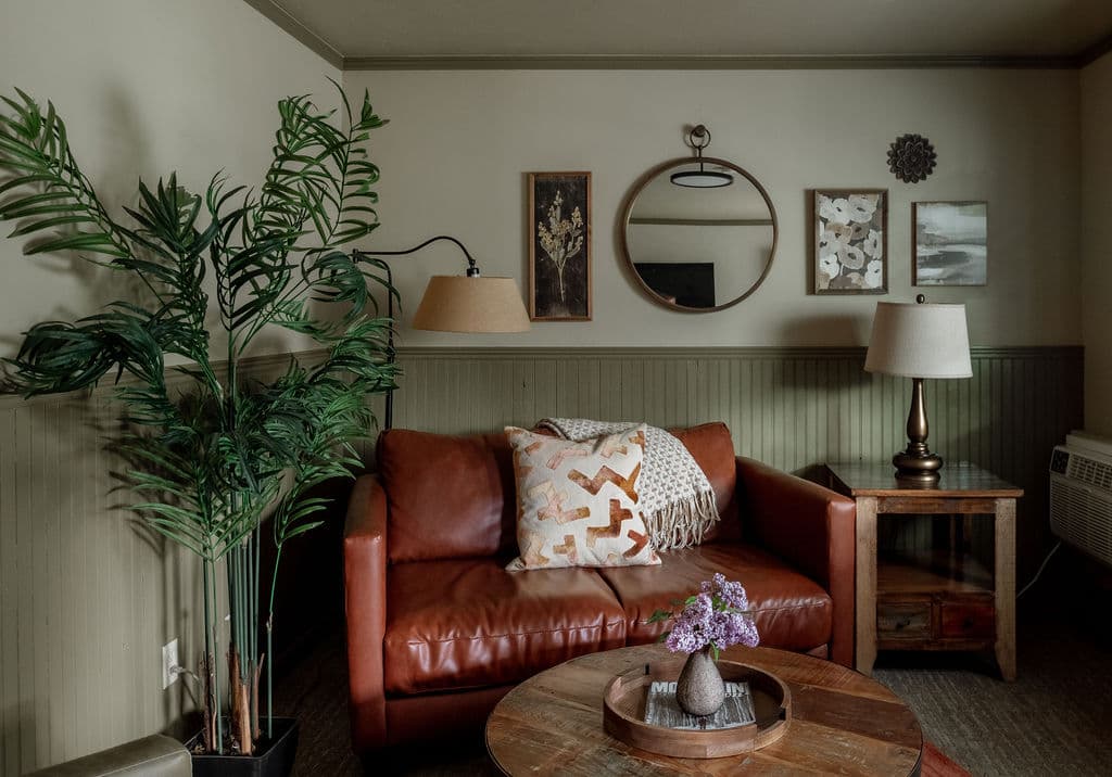 sitting room, red leather love seat, and two brown chairs with coffee table in middle.