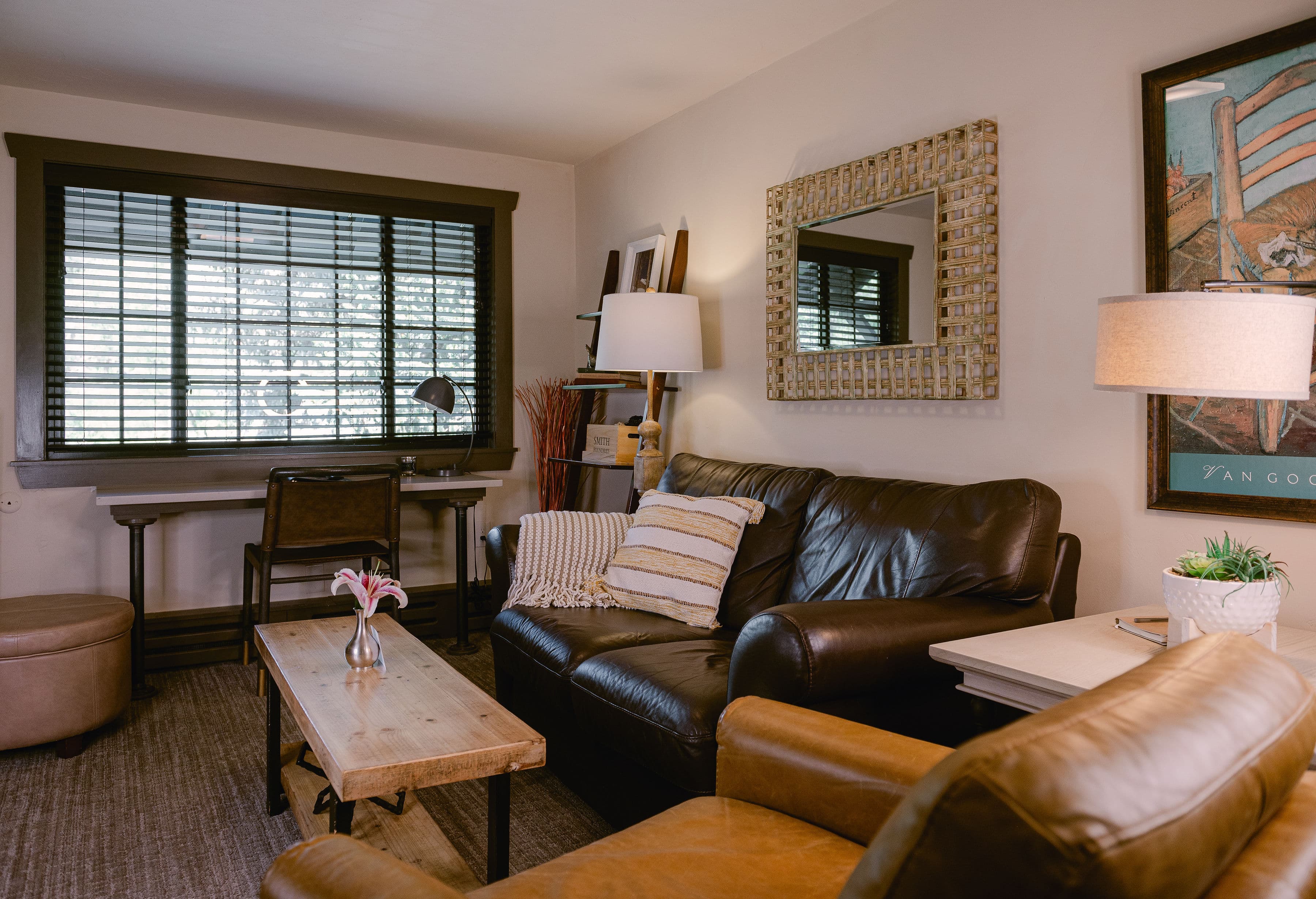sitting room, black leather love seat, and an armed sitting chair with coffee table in middle.