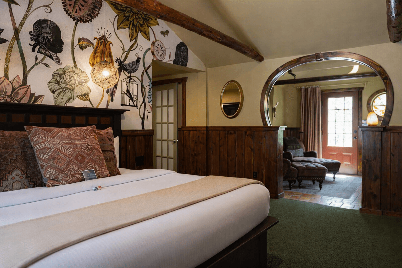 King bed with red throw and fuzzy red decorative pillows. Log beams above