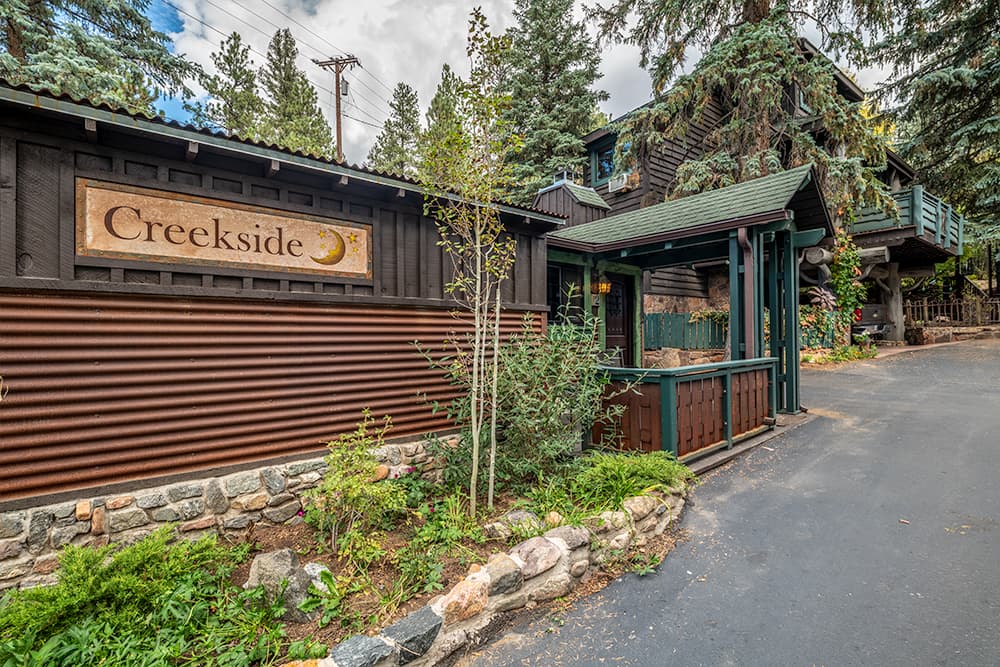 Trees in front of wood cabin with deck