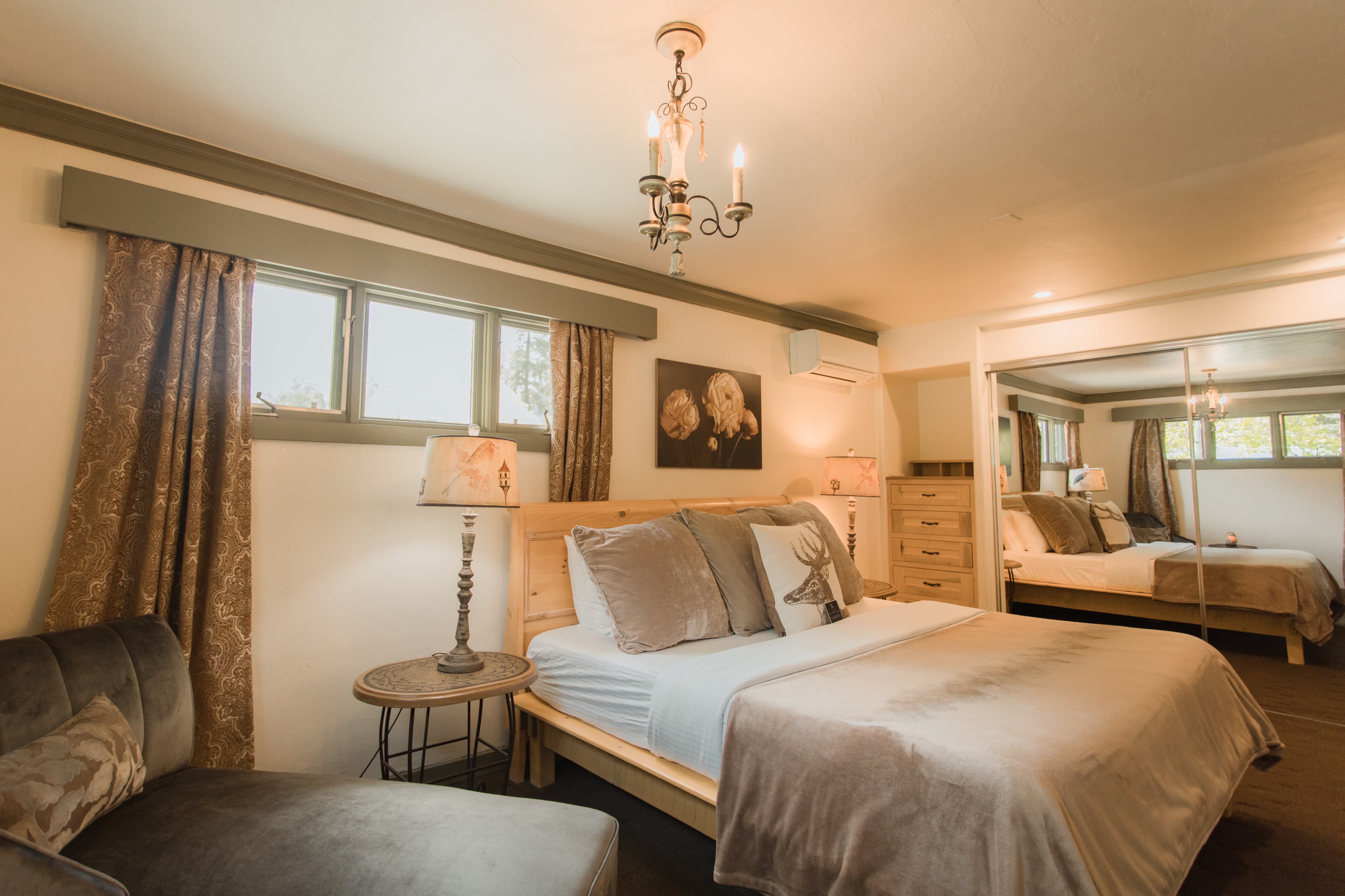platform bed, gray chaise lounge, lamp and tan curtains
