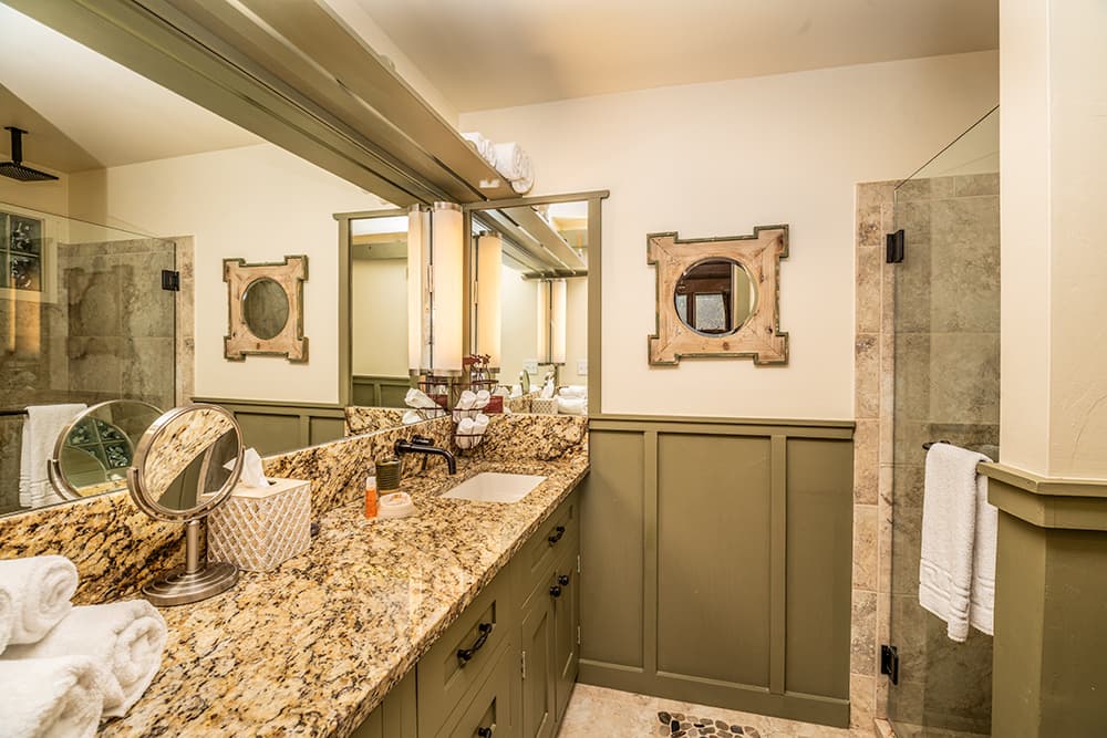 white and brown marble counter tops, glass shower, large mirrors
