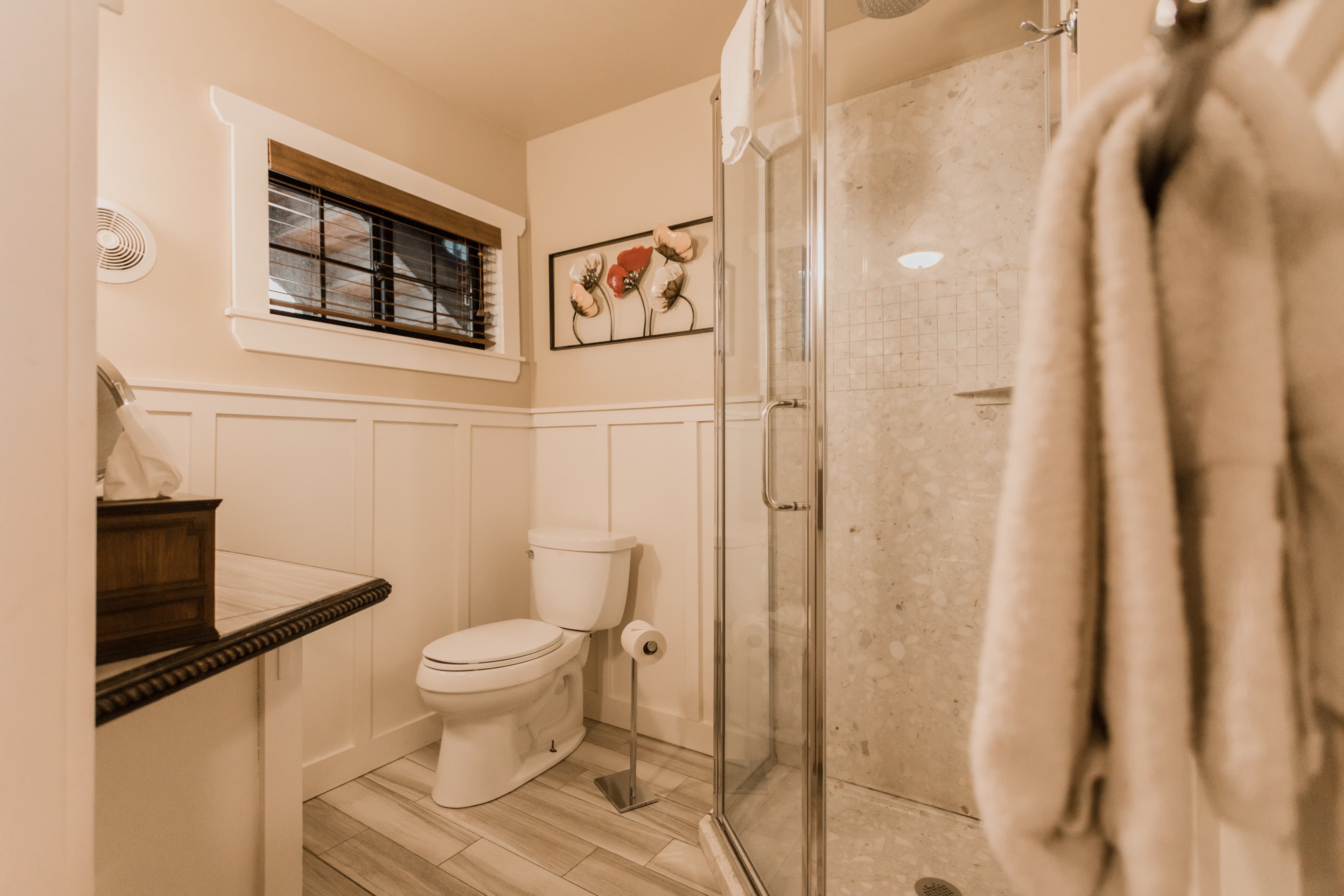 bathroom with white tile standing shower and white wainscoting on walls