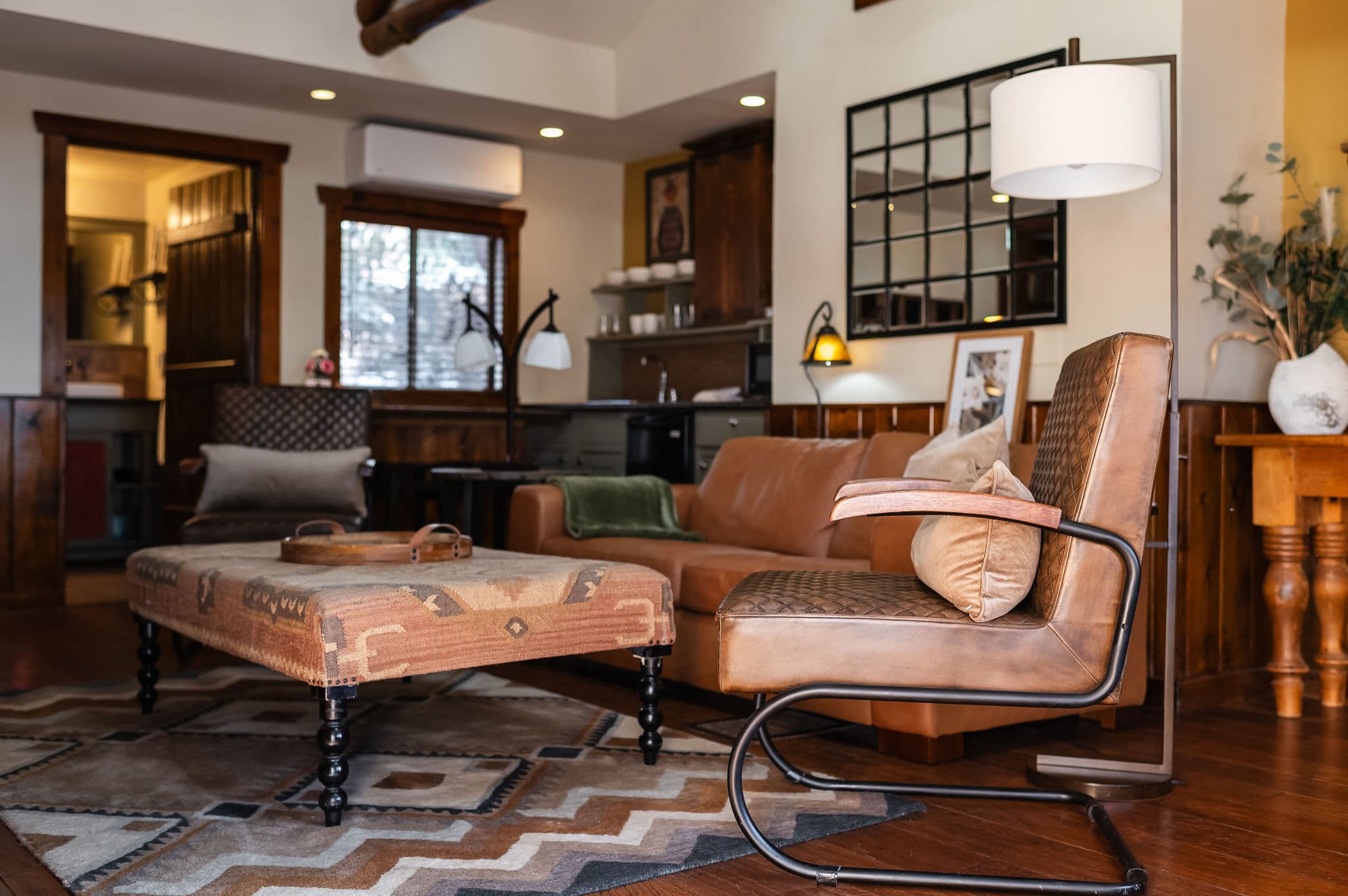 large room high ceilings, quilted leather arm chair and table and leather love seat