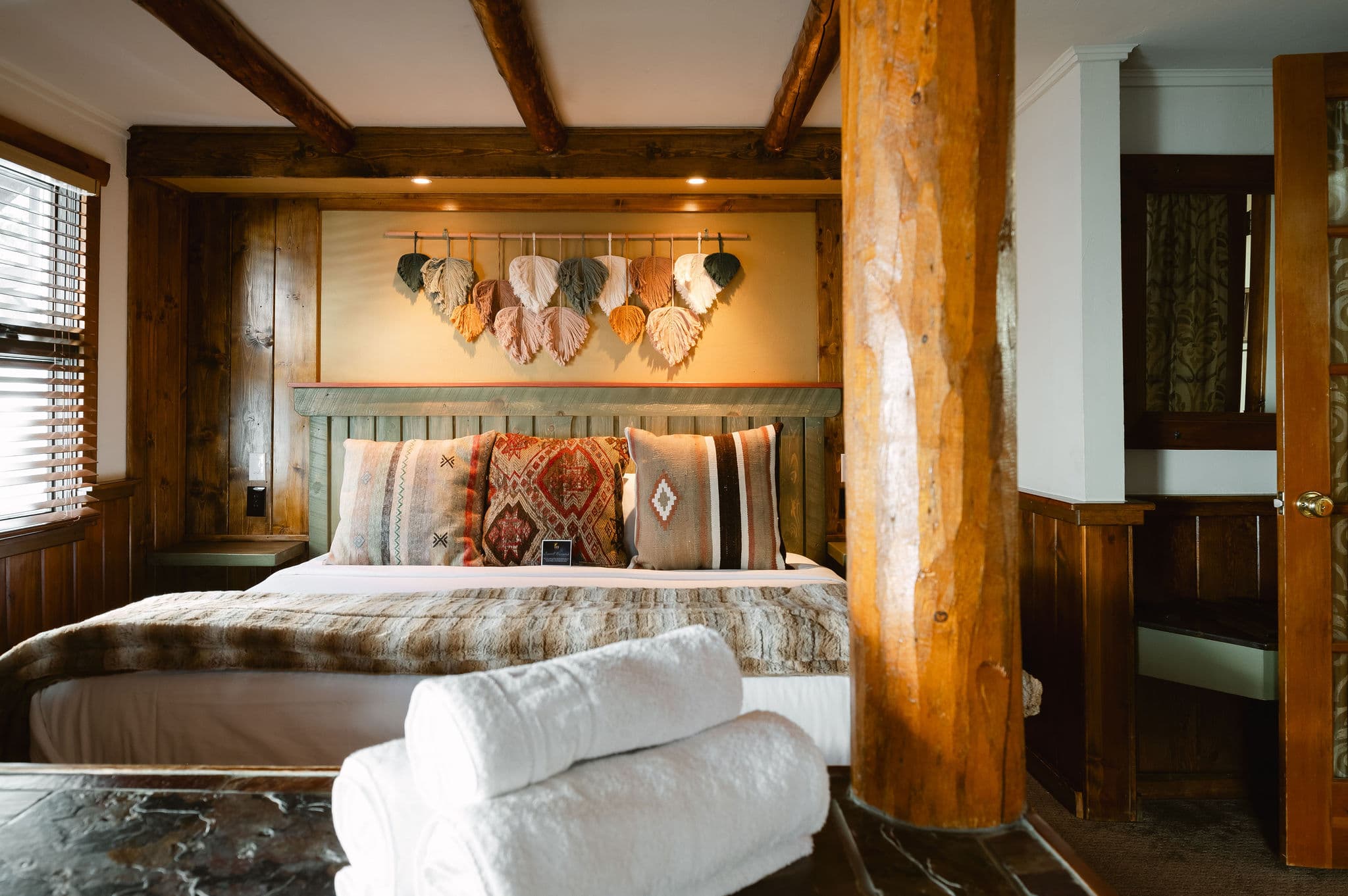king bed with decorative wall hanging and wood walls