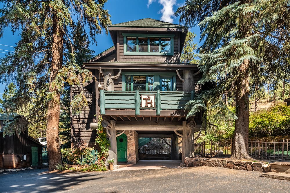 3 story building on large trees, blue sky and big trees