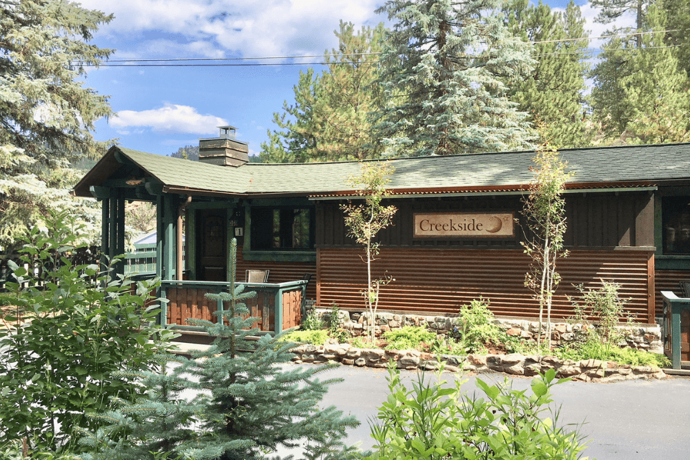 Trees in front of wood cabin with deck