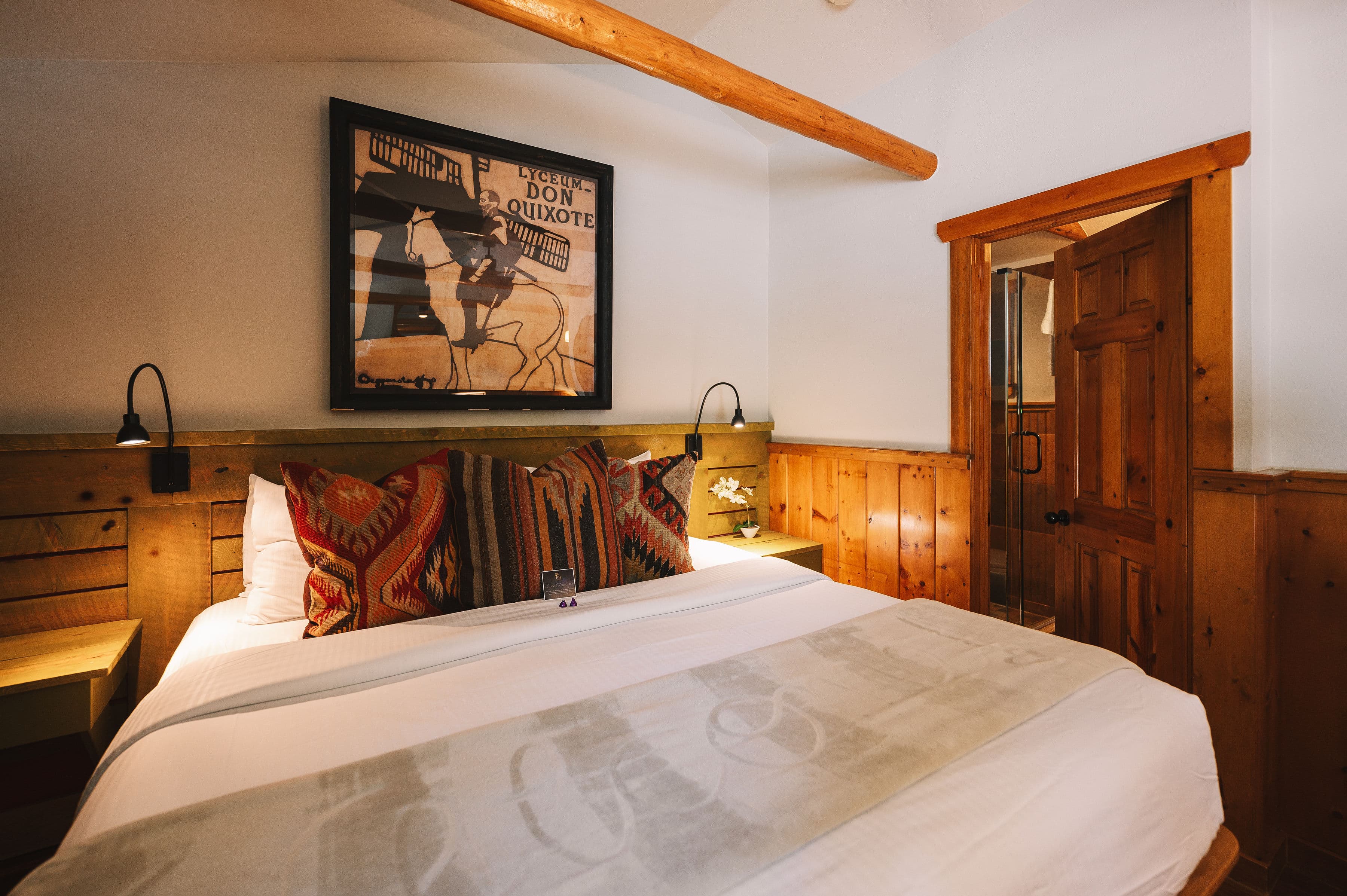 king bed soft gold blanket and wood beams