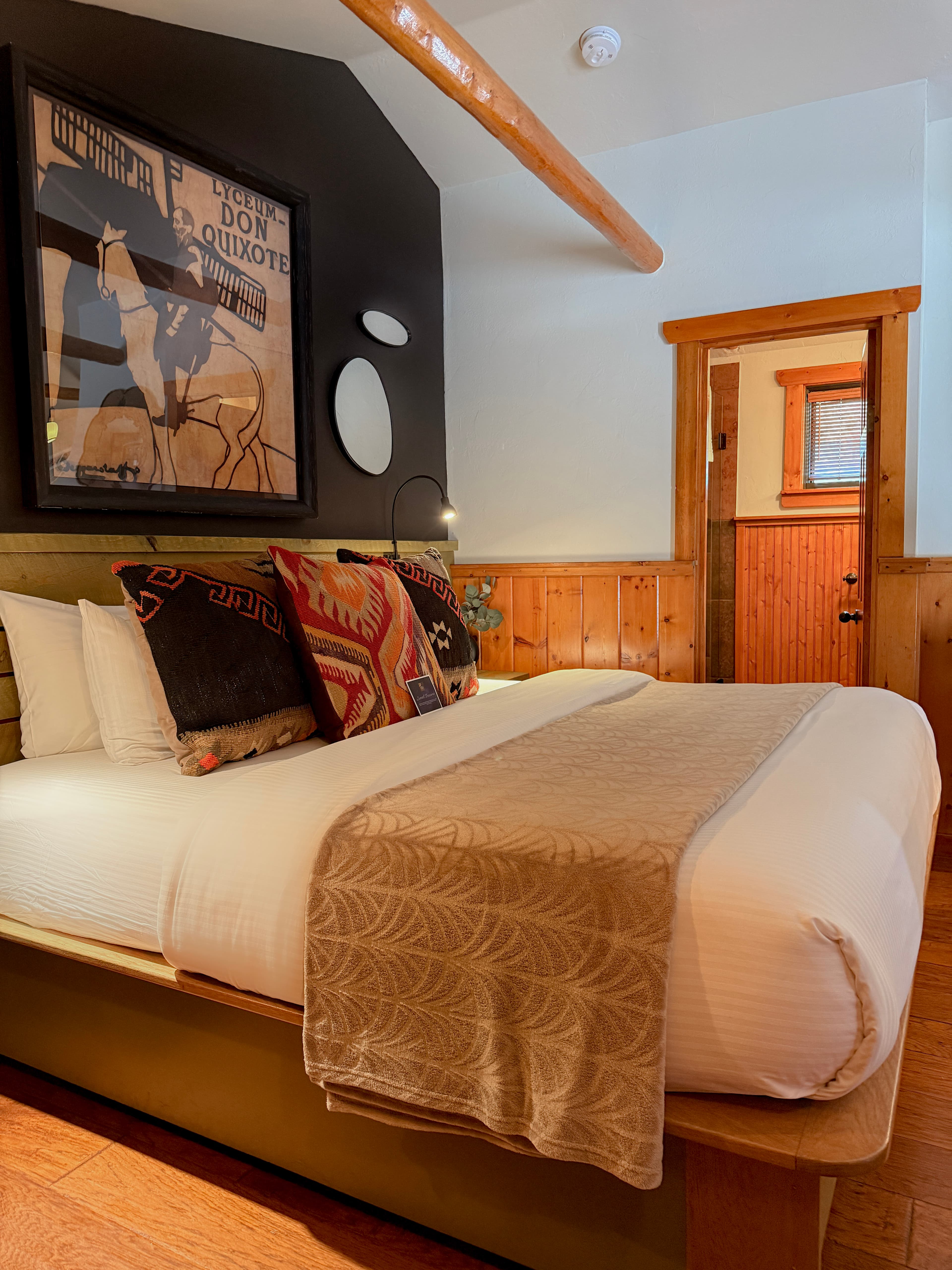 king bed soft gold blanket and wood beams