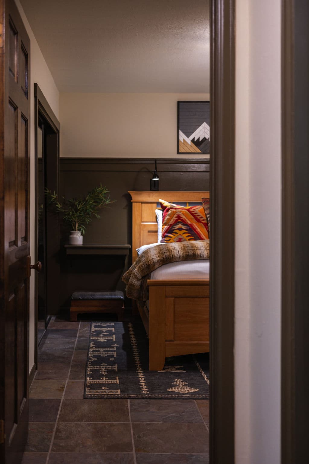 Kind bed, zoomed out, veiw of area rug and wall lamp