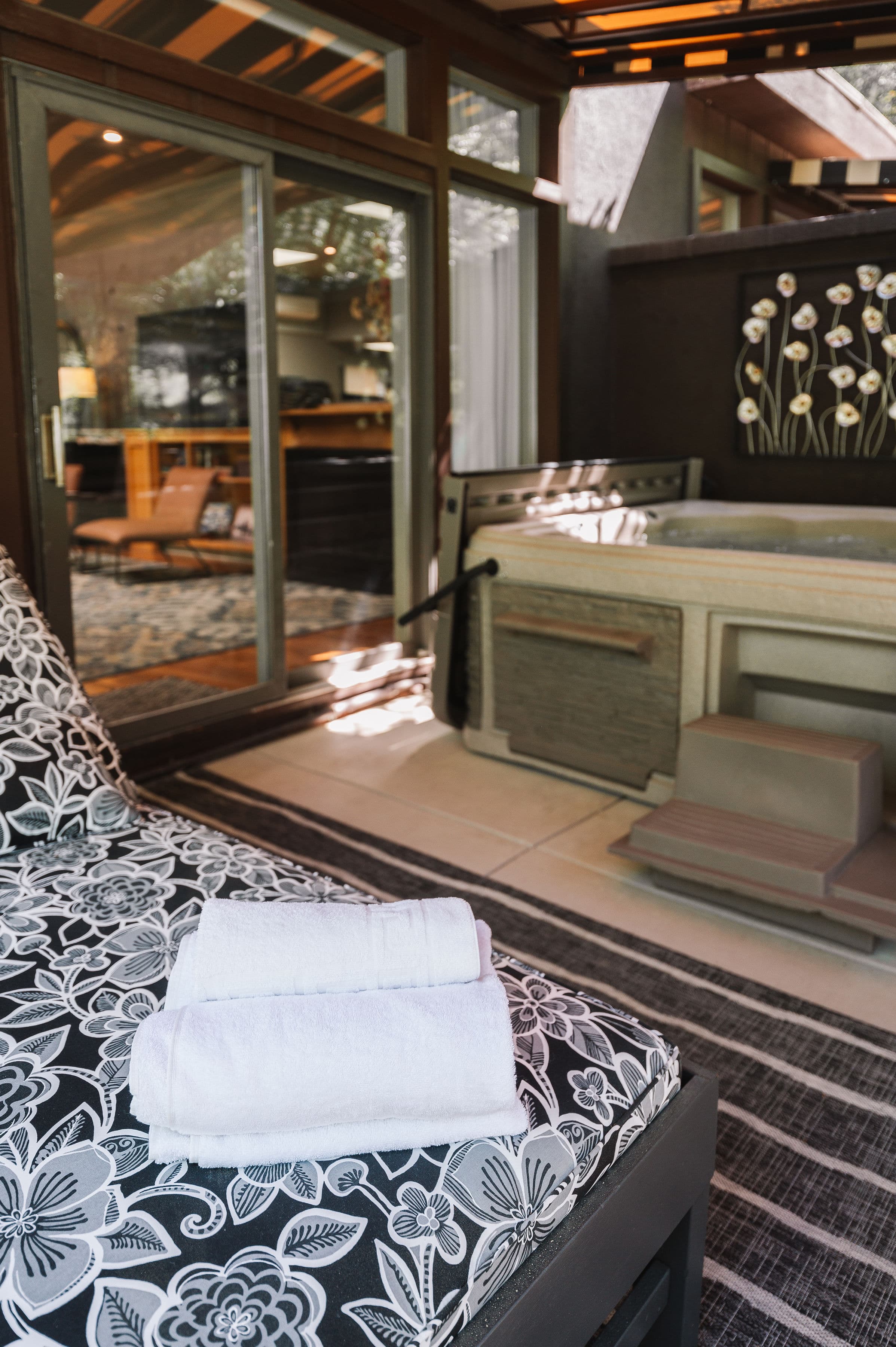 outdoor hot tub under striped canopy and large outdoor lounge chair