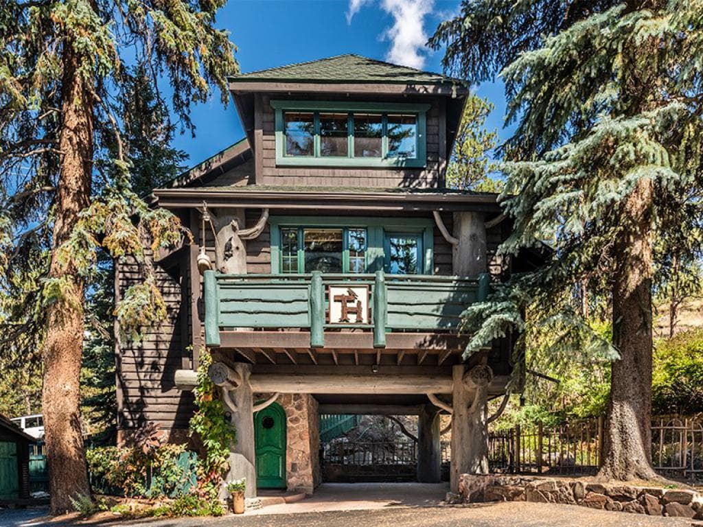 3 story building on large trees, blue sky and big trees