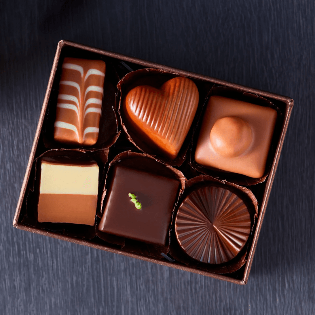 A box of assorted chocolates featuring various shapes and designs.