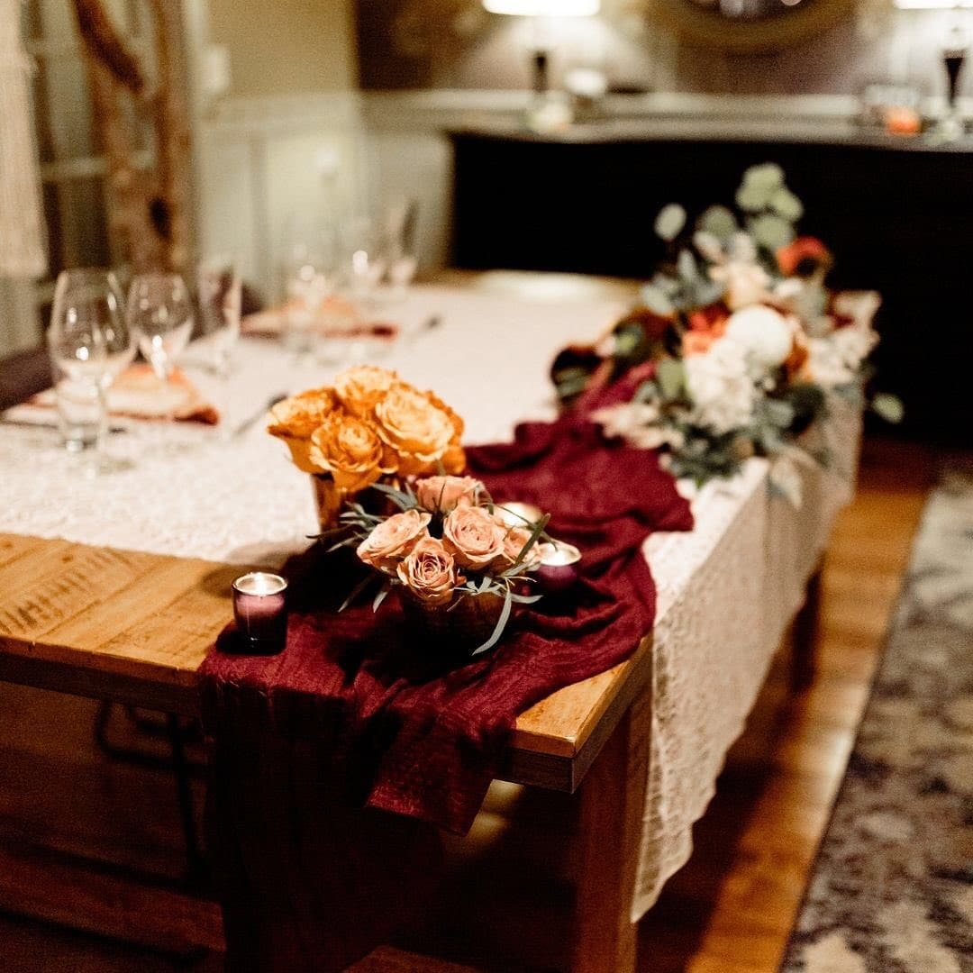 A beautifully set dining table adorned with floral arrangements and candles.