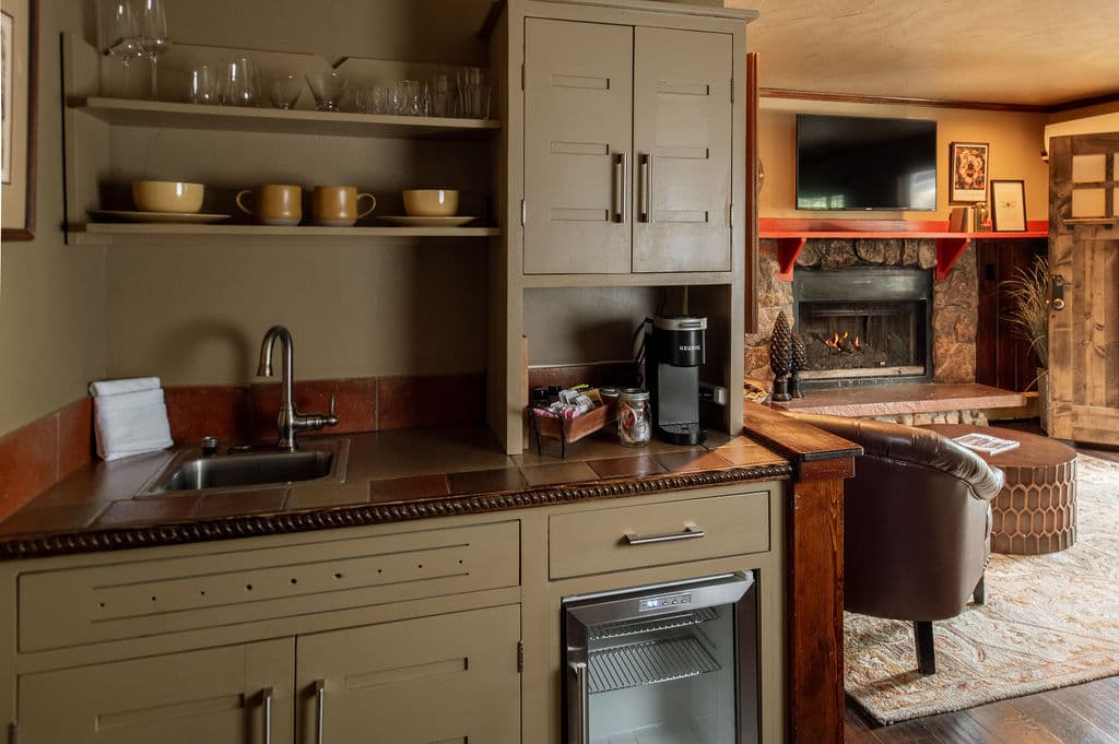 Cozy interior view featuring a kitchenette, fireplace, and comfortable seating area.