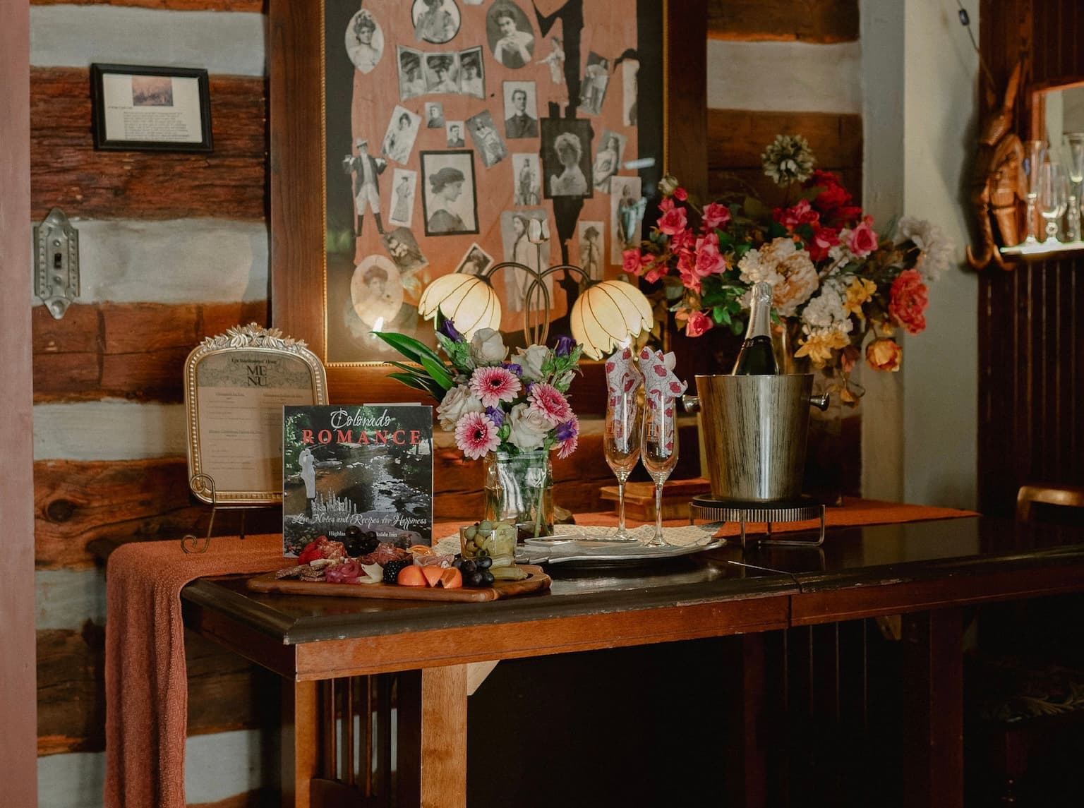 A rustic bar setting adorned with vintage photos, flower arrangements, and a magazine titled "A Reader's Romance."