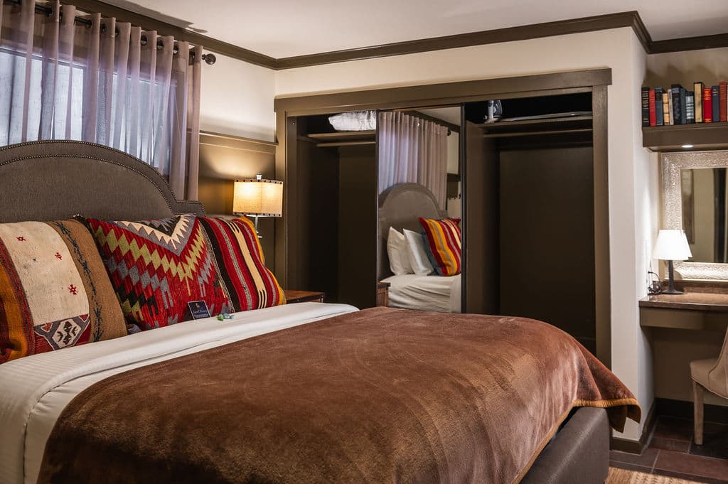 Cozy bedroom with a large bed, decorative pillows, and a stylish desk area.