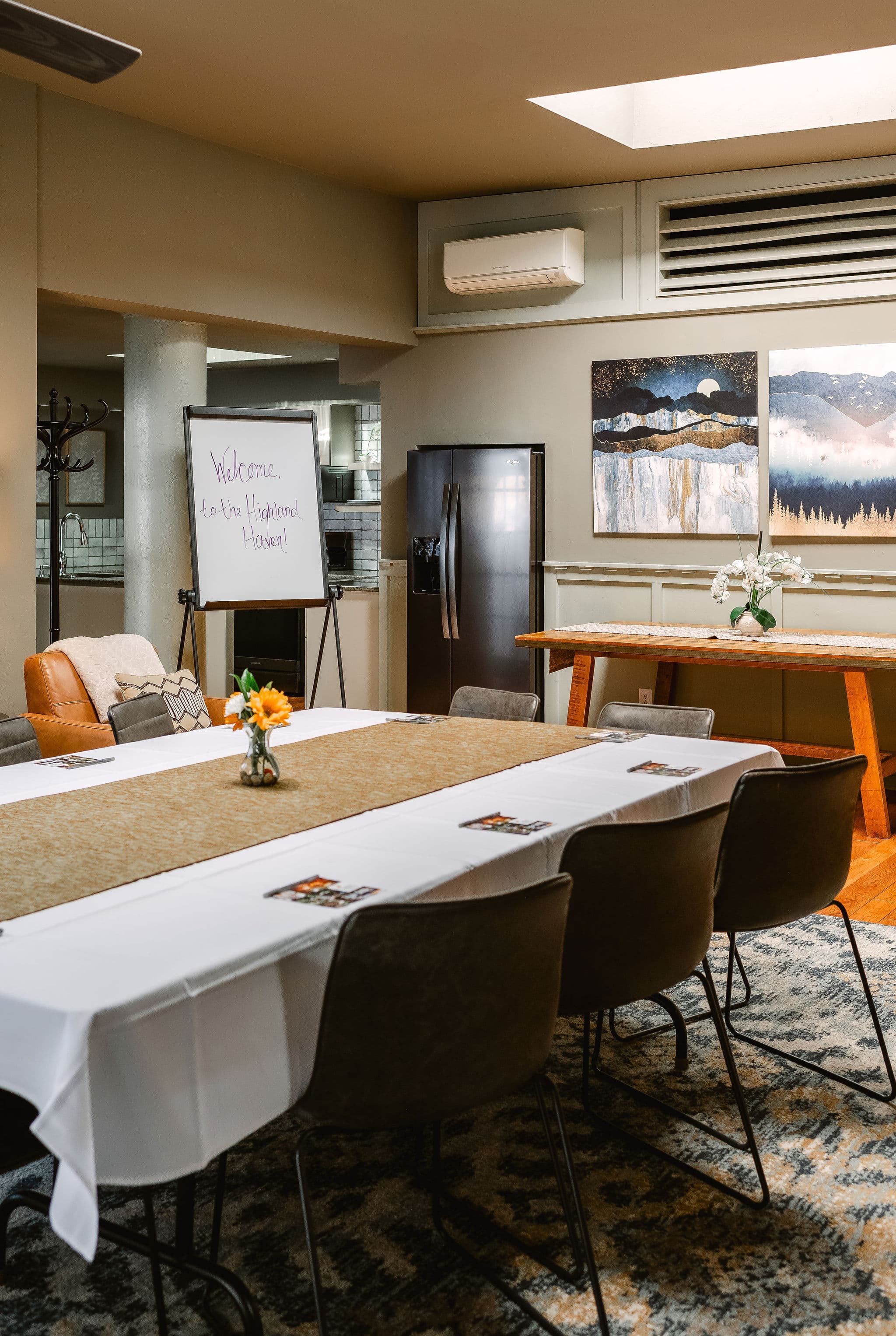 A welcoming meeting room featuring a long table, chairs, and decorative artwork.