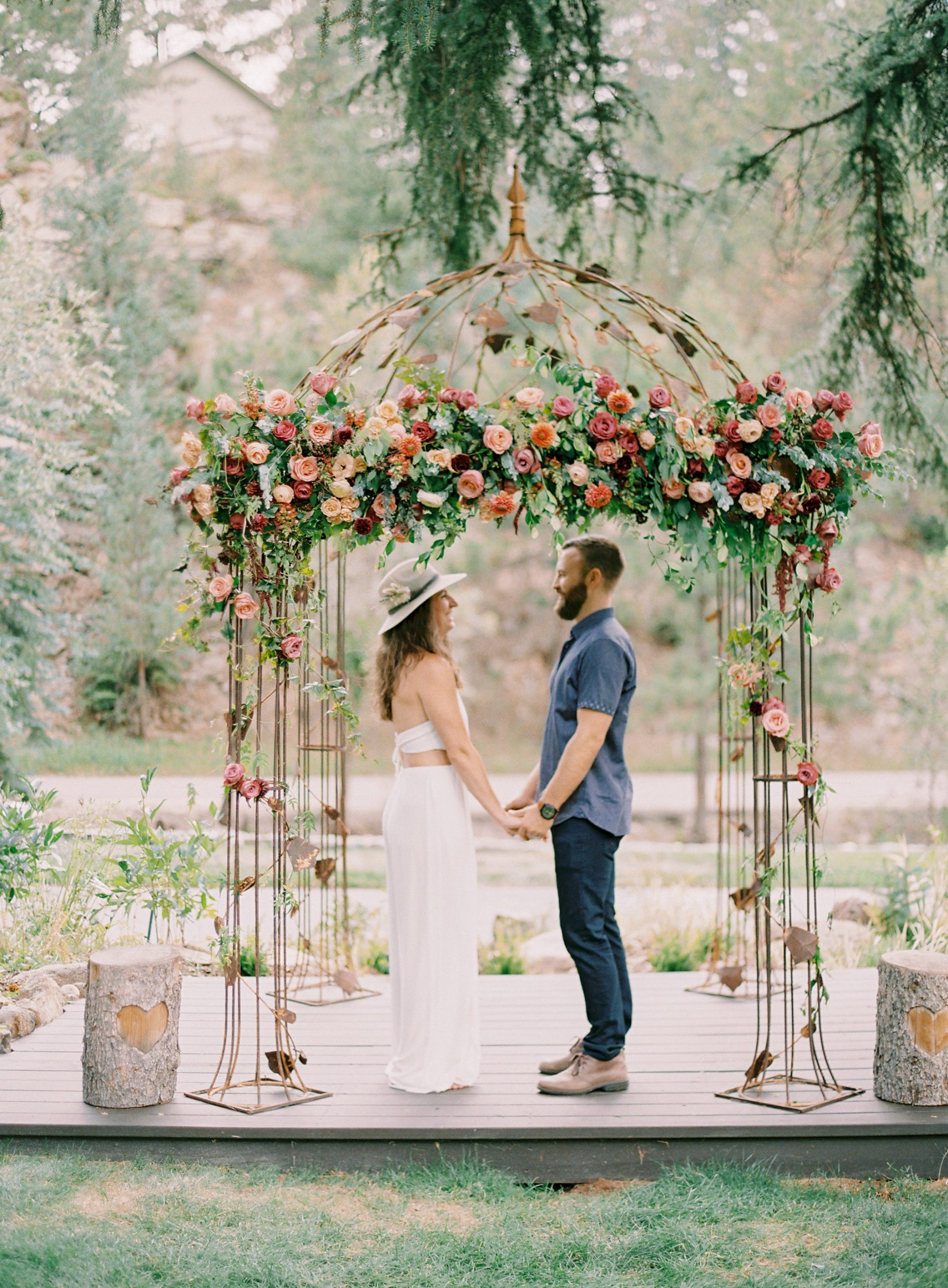 couple under wrought iron gazebo with flowers